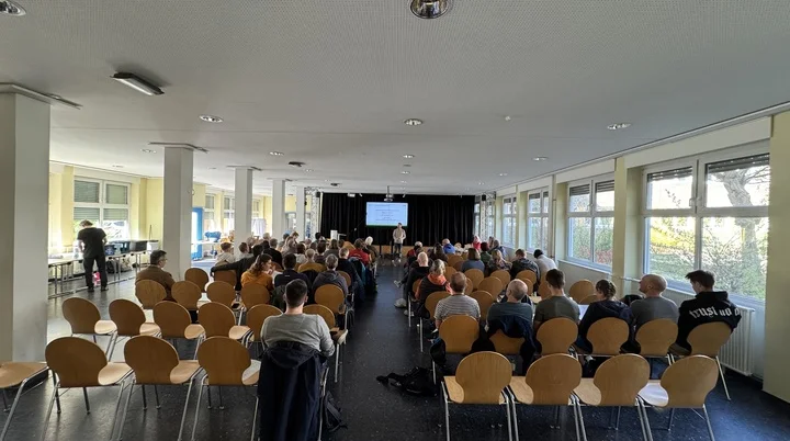 Zahlreiche Personen sitzen in Reihen und verfolgen die Präsentation bei der DAV Dortmund Mitgliederversammlung. | © DAV Dortmund