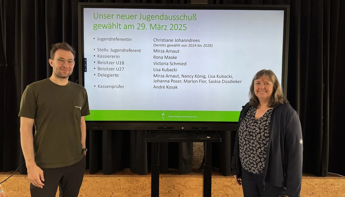 Zwei Personen stehen vor einer großen Leinwand mit der Präsentation des neuen Jugendausschusses des DAV Dortmund. | © DAV Dortmund