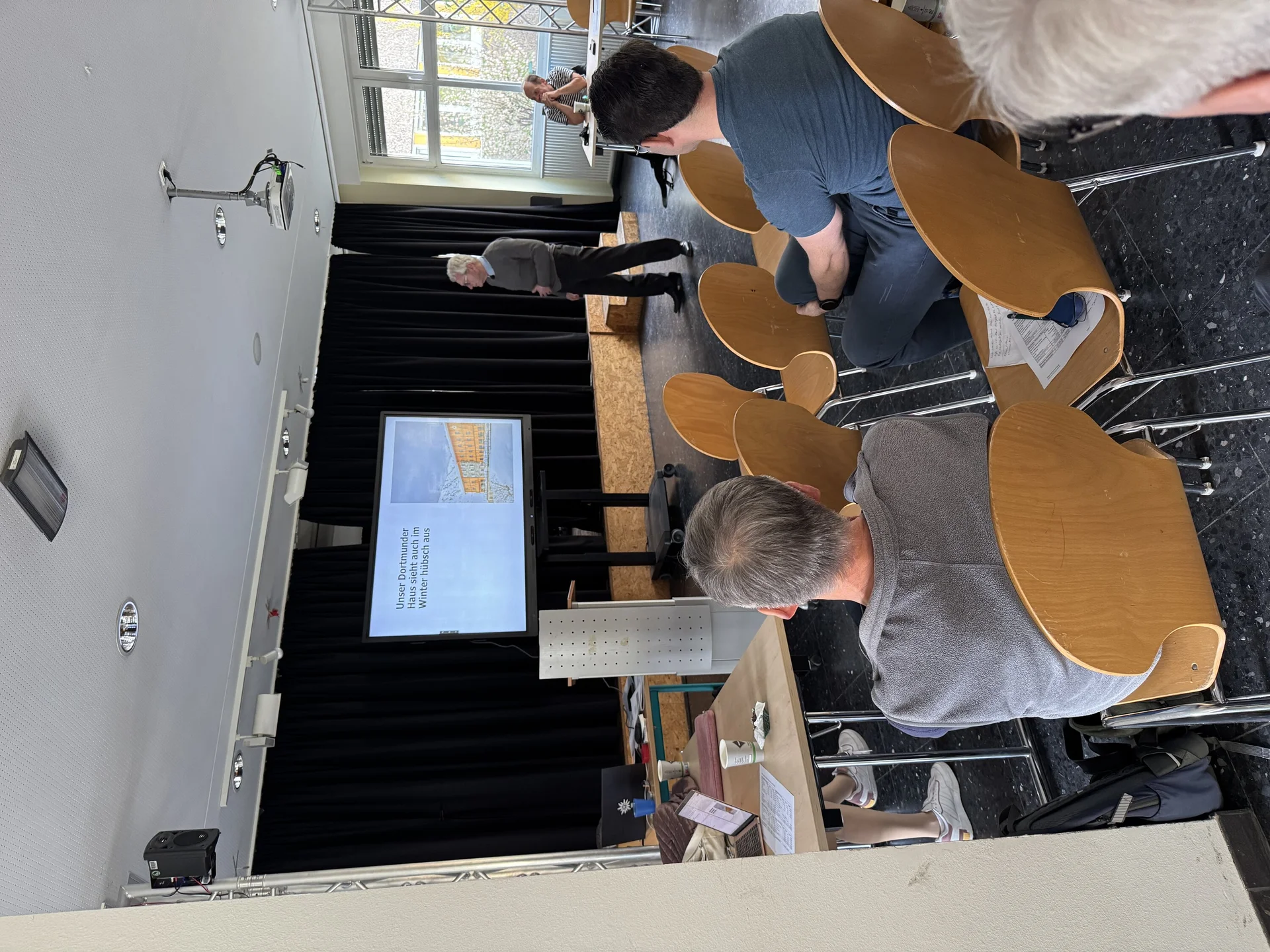 Zahlreiche Personen sitzen in Reihen und verfolgen die Präsentation bei der DAV Dortmund Mitgliederversammlung. | © DAV Dortmund