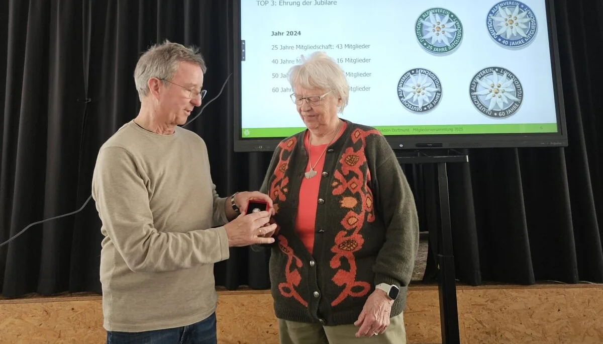 Norbert gibt eine DAV Edelweiss Nadel zu einer Jubilarin | © DAV Dortmund