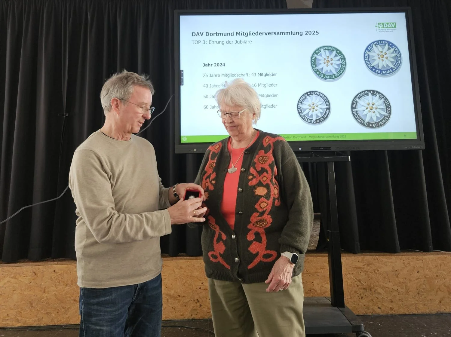 Norbert gibt eine DAV Edelweiss Nadel zu einer Jubilarin | © DAV Dortmund