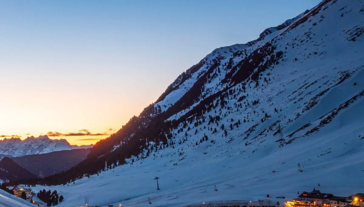Titelbild des DAV Dortmund Sektionshefts 2024 mit verschneiter Alpenlandschaft und leuchtendem Tal bei Dämmerung. | © DAV Dortmund