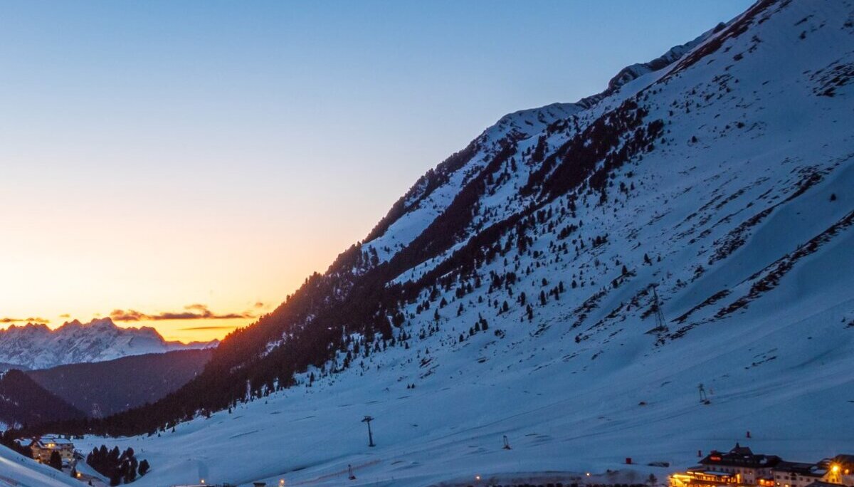 Titelbild des DAV Dortmund Sektionshefts 2024 mit verschneiter Alpenlandschaft und leuchtendem Tal bei Dämmerung. | © DAV Dortmund