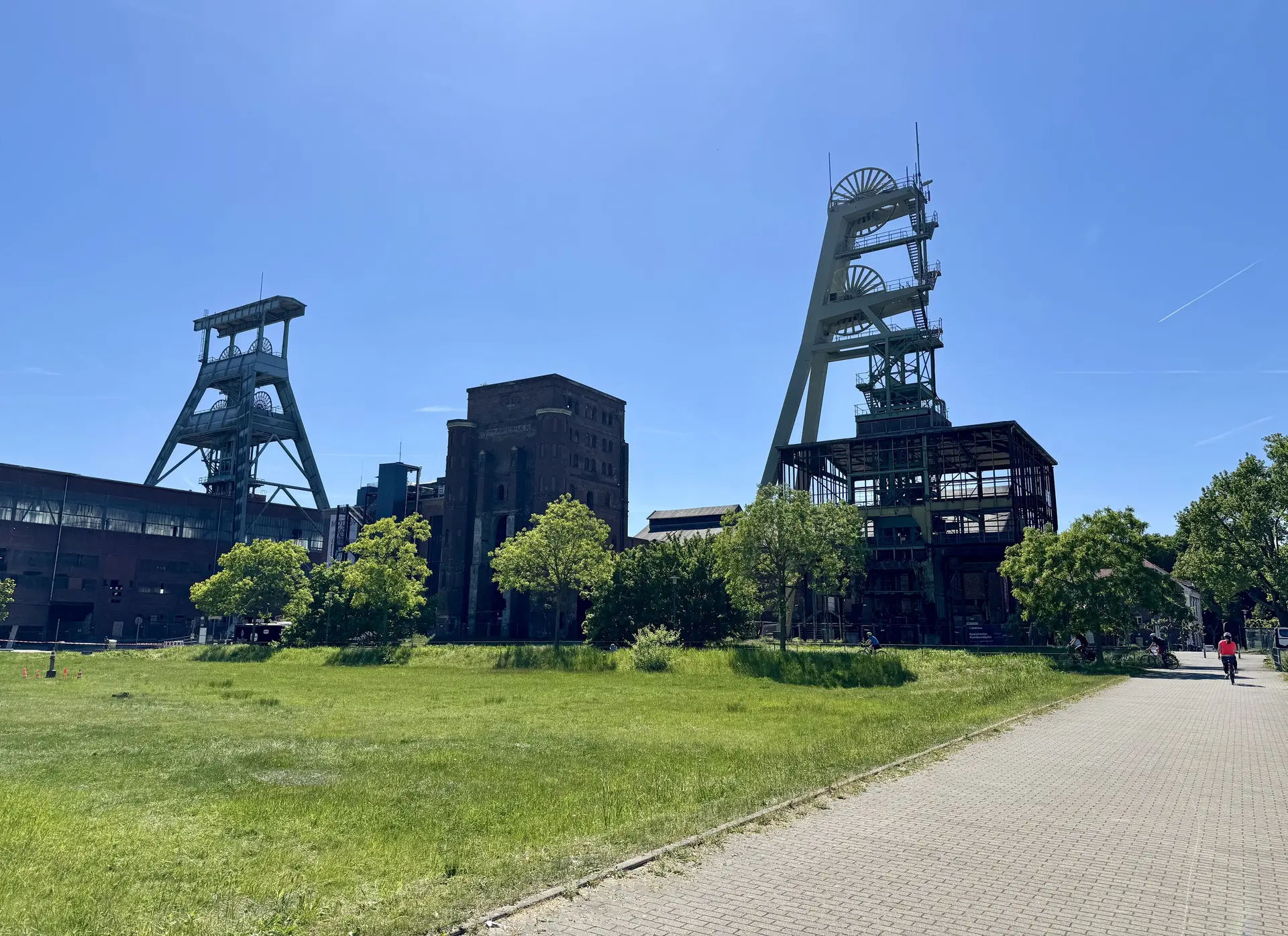 Alte Fördertürme und Gebäude eines ehemaligen Bergwerks vor blauem Himmel. | © DAV Dortmund
