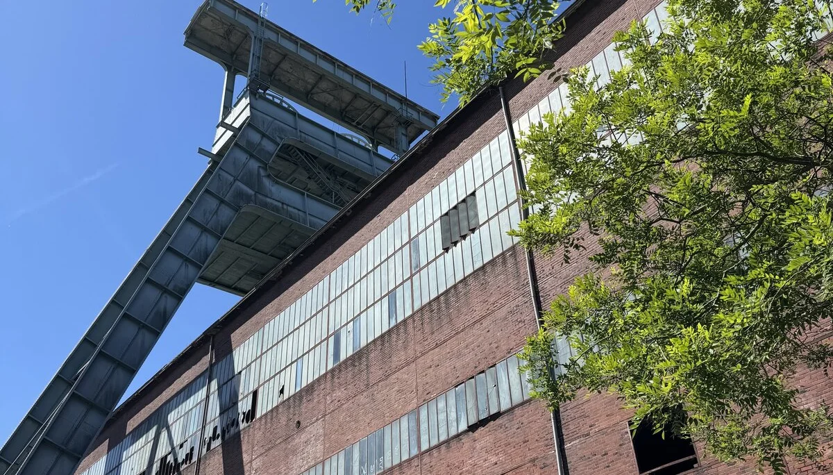 Roter Backsteinbau mit Stahlkonstruktion und Förderturm, aufgenommen aus der Froschperspektive. | © DAV Dortmund