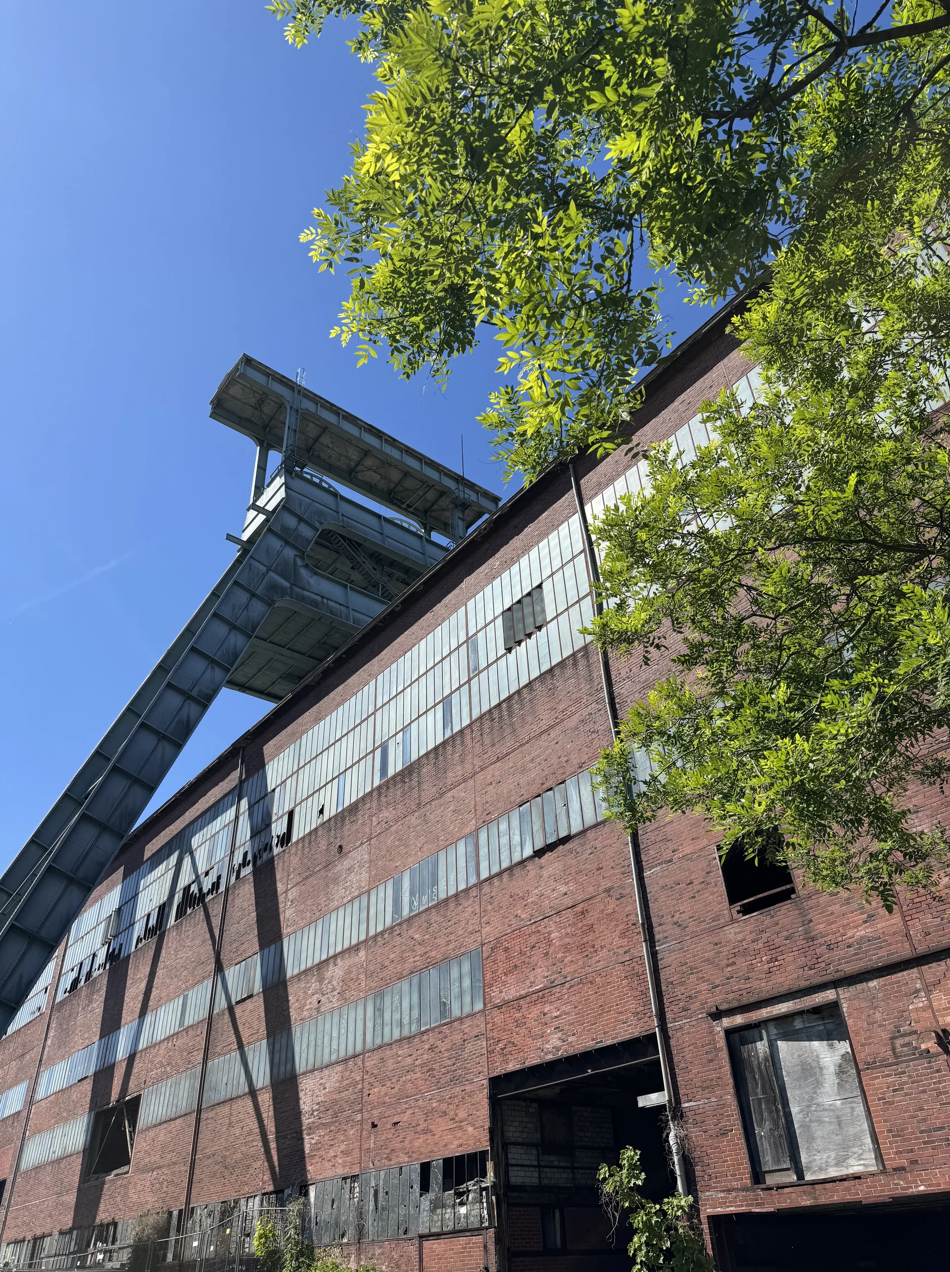 Roter Backsteinbau mit Stahlkonstruktion und Förderturm, aufgenommen aus der Froschperspektive. | © DAV Dortmund