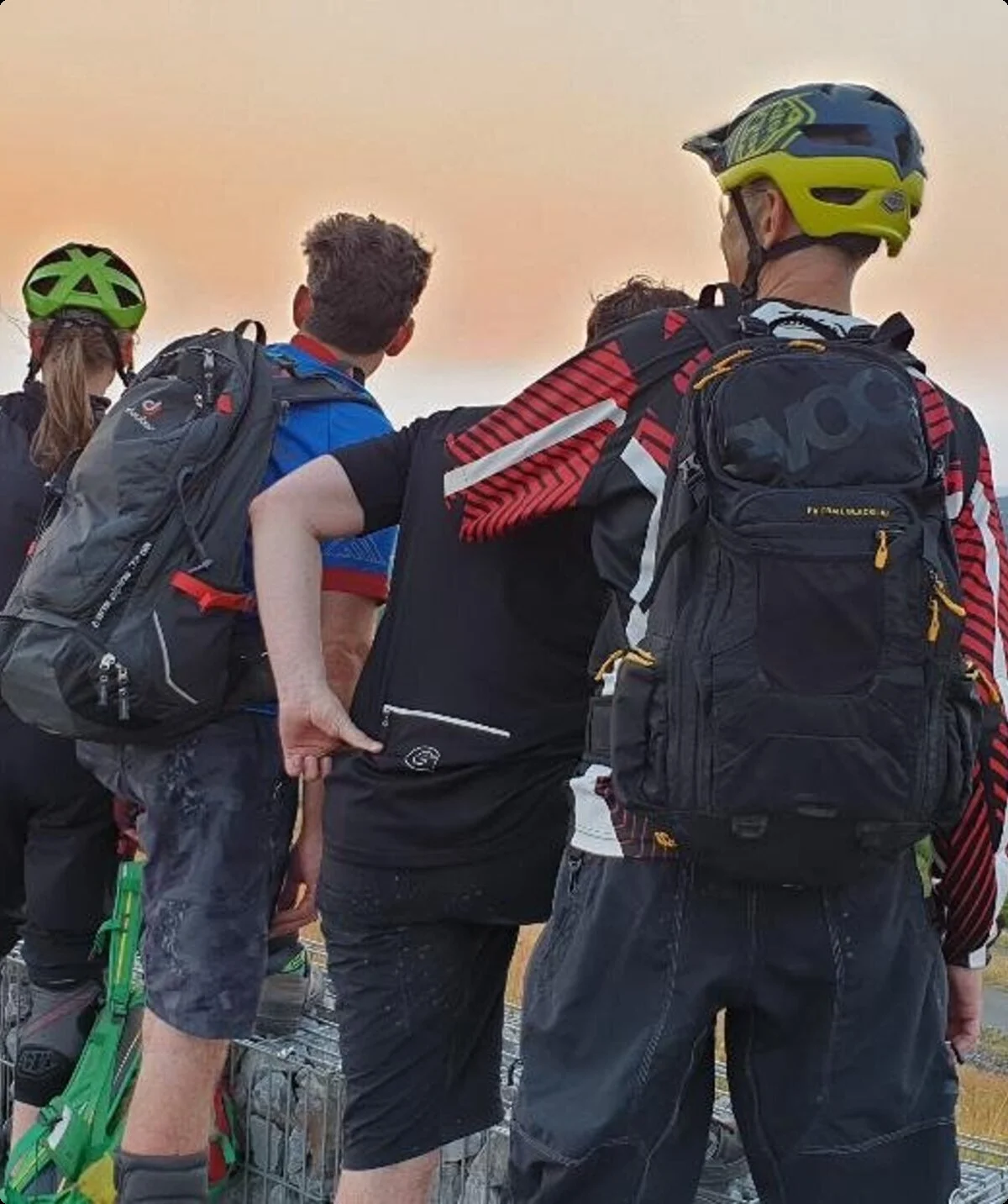 Mountainbiker*innen stehen auf einer Halde und schauen dem Sonnenuntergang entgegen. | © DAV Dortmund