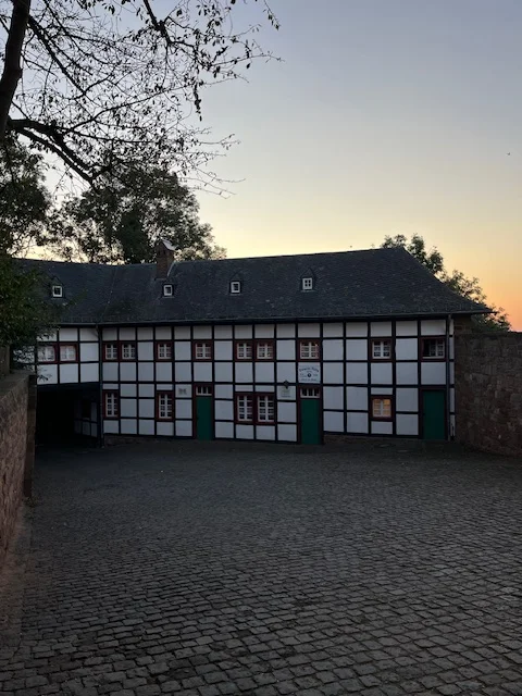 Ein altes Fachwerkhaus mit Kopfsteinpflaster im Hof, aufgenommen bei Sonnenuntergang. | © DAV Dortmund
