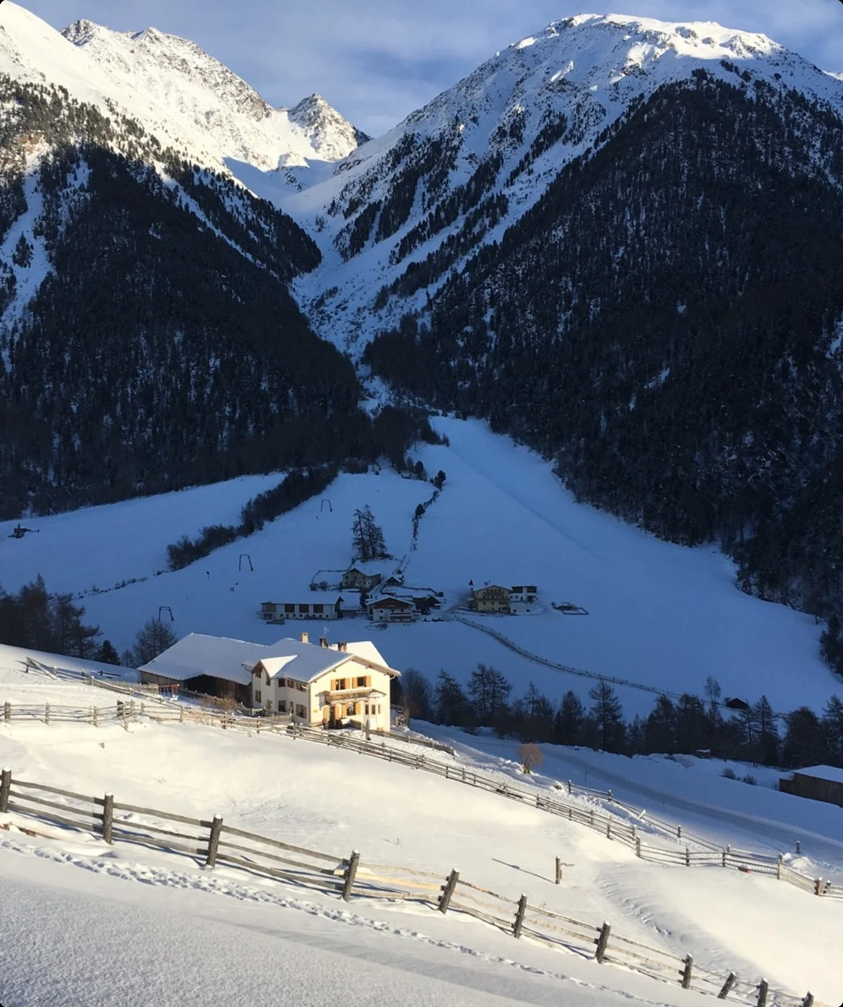 Ein verschneites Tal mit einem Bauernhof im Vordergrund, umgeben von schneebedeckten Bergen. | © DAV Dortmund