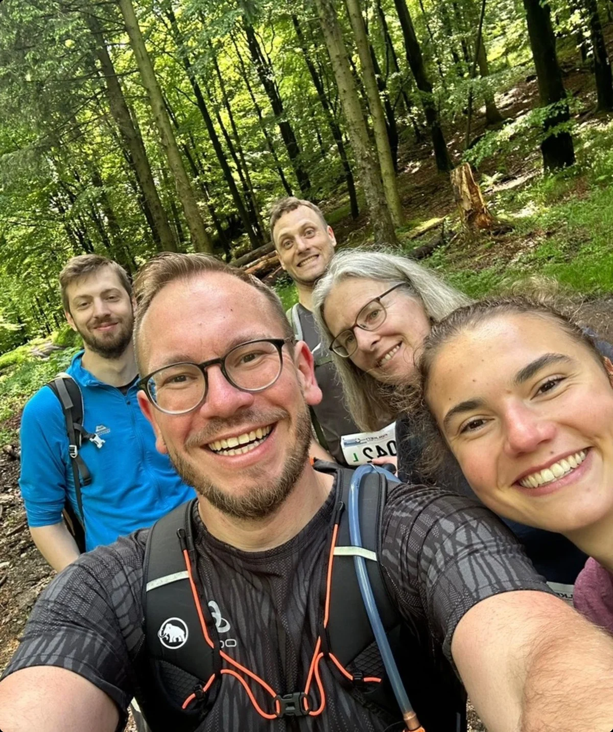 Sechs Personen machen ein Selfie bei einer Wanderung im sommerlichen Wald. Alle lachen in die Kamera. | © DAV Dortmund