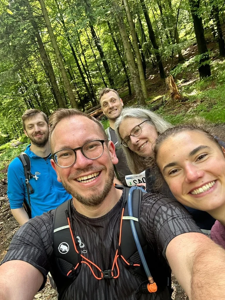 Sechs Personen machen ein Selfie bei einer Wanderung im sommerlichen Wald. Alle lachen in die Kamera. | © DAV Dortmund