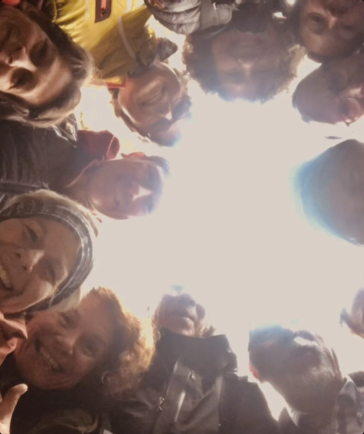 Gruppe von Menschen blickt im Kreis stehend nach unten in die Kamera und lacht. | © DAV Dortmund