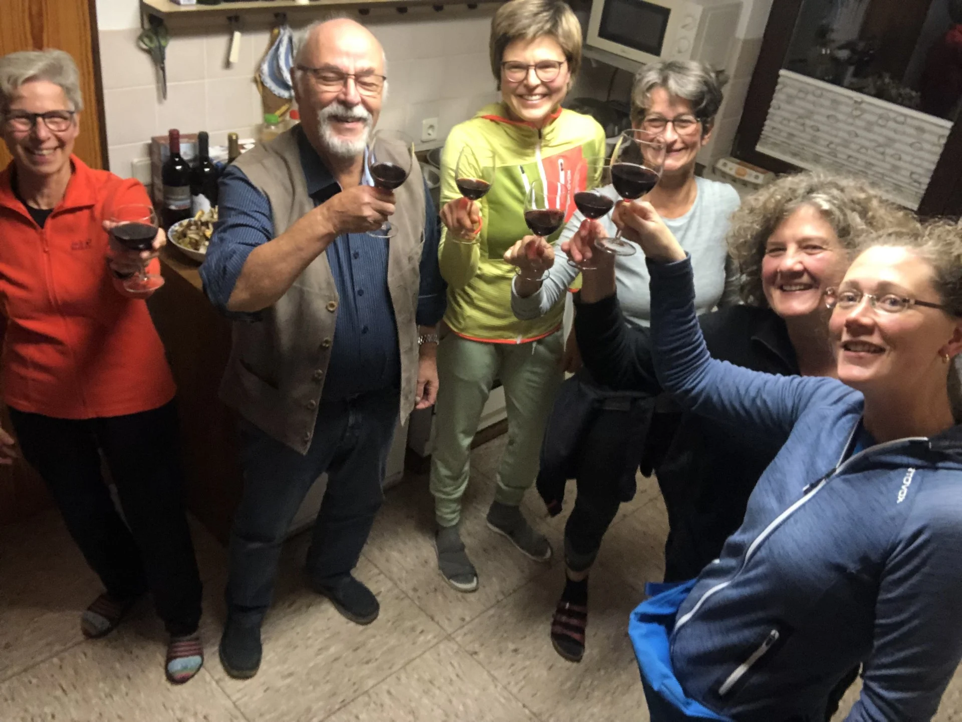 Sechs Personen stoßen mit Rotweingläsern in einer gemütlichen Küche an. | © DAV Dortmund