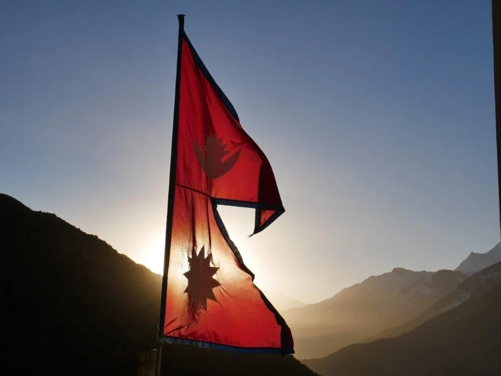 Zwei Nepal-Flaggen im Gegenlicht der untergehenden Sonne zwischen Bergen. | © DAV Dortmund