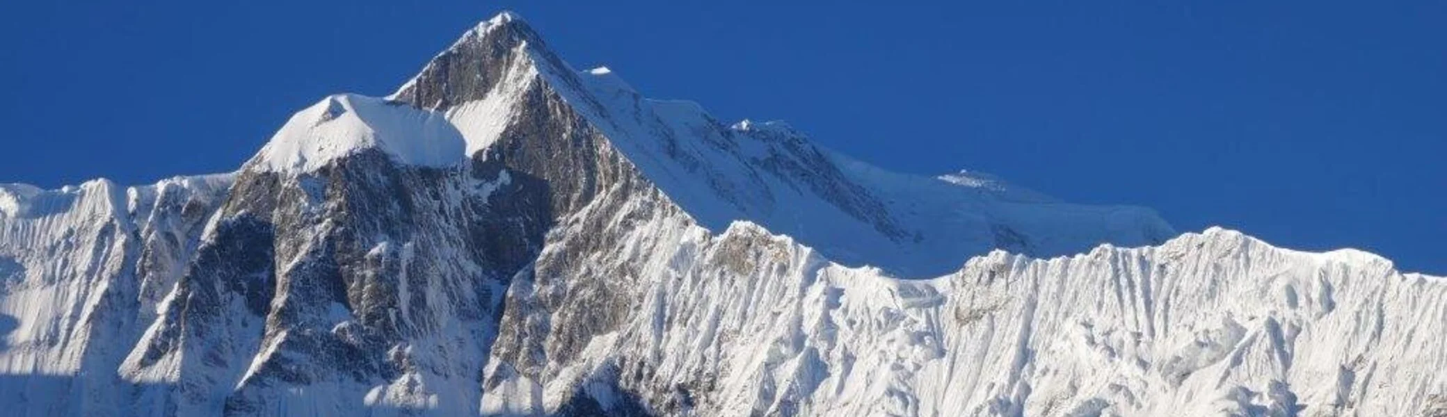 Schneebedeckter Berggipfel im Sonnenlicht mit scharfen Konturen und blauem Himmel. | © DAV Dortmund