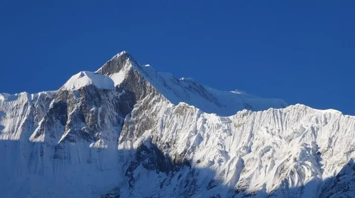 Schneebedeckter Berggipfel im Sonnenlicht mit scharfen Konturen und blauem Himmel. | © DAV Dortmund