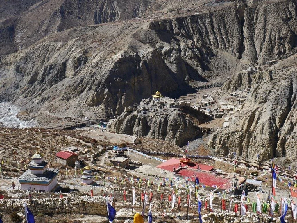 Dorf in einer trockenen Gebirgslandschaft mit vielen bunten Gebetsfahnen. | © DAV Dortmund
