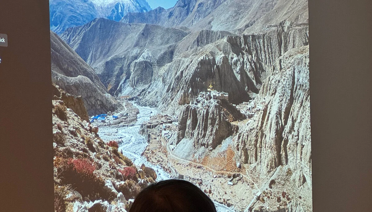 Eine Person blickt auf ein projiziertes Bild mit tiefem Tal und verschneiten Bergen. | © DAV Dortmund