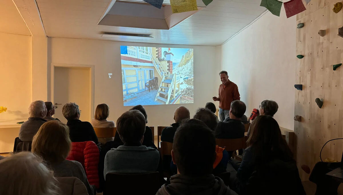 Menschen sitzen im Raum und verfolgen eine Präsentation mit Projektorbild an der Wand. | © DAV Dortmund