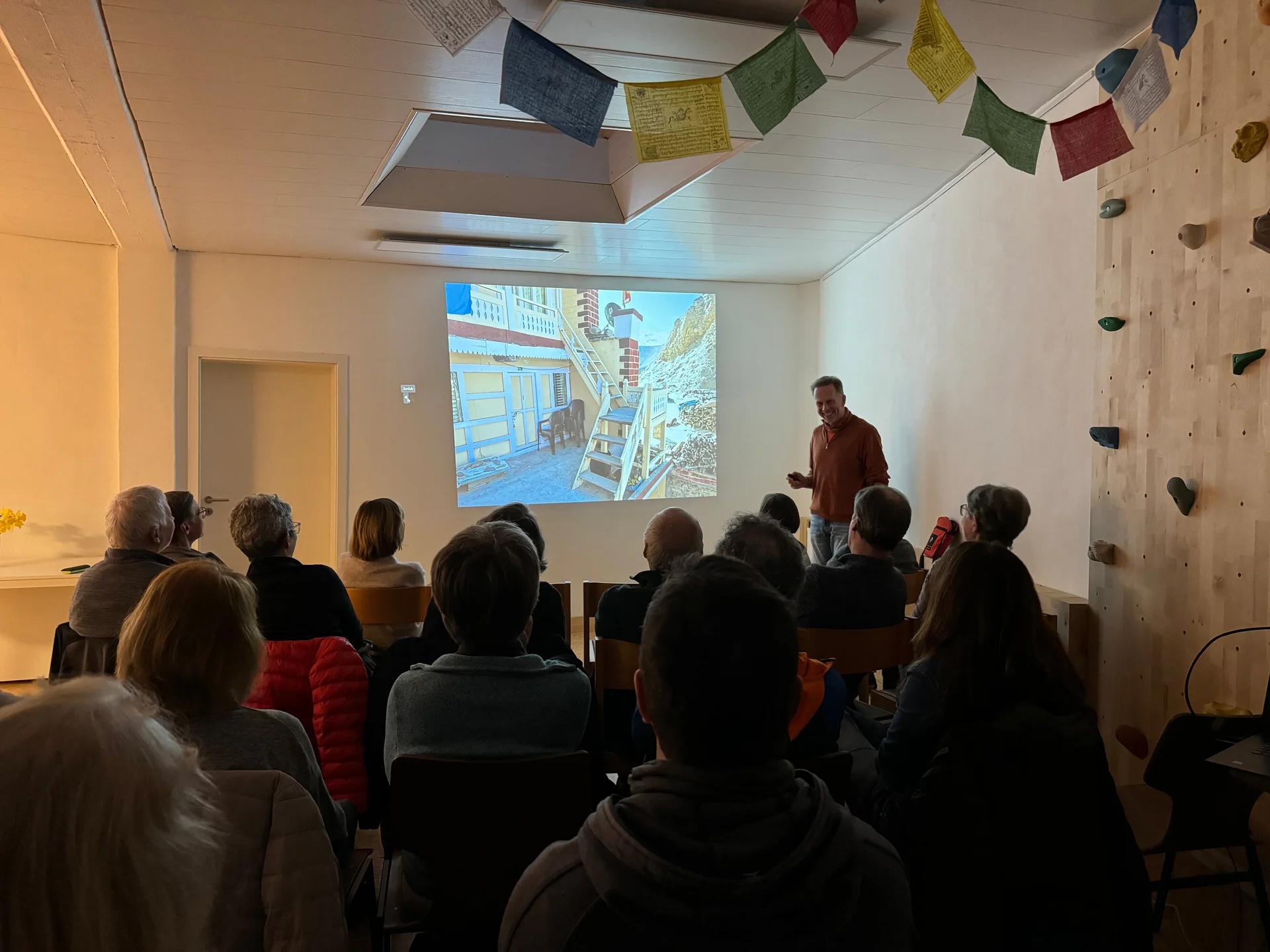 Menschen sitzen im Raum und verfolgen eine Präsentation mit Projektorbild an der Wand. | © DAV Dortmund