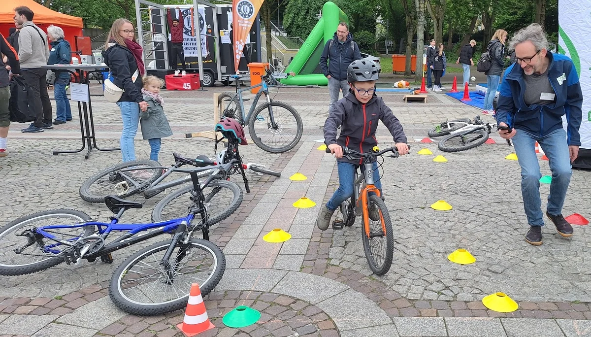 Junge Person fährt mit Fahrrad durch markierten Parcours, betreut von einer erwachsenen Person. | © DAV Dortmund