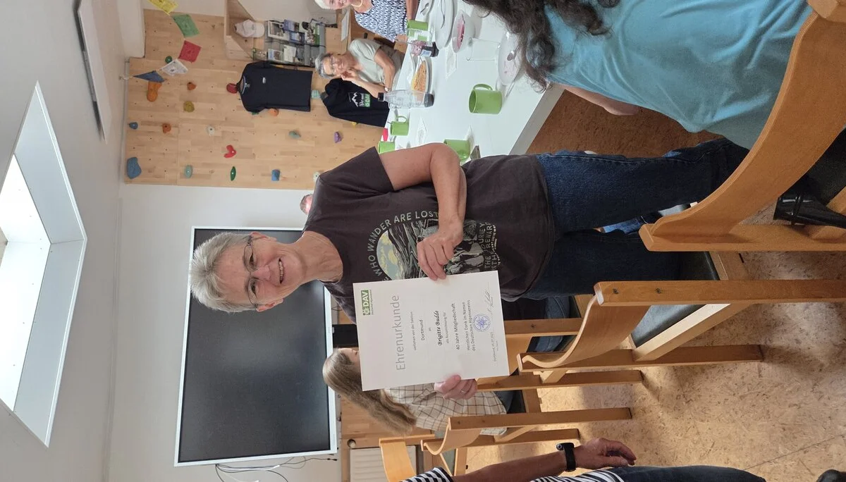 Brigitte hält stolz ihre Ehrenurkunde für 40 Jahre Mitgliedschaft in der DAV Sektion Dortmund in die Kamera. | © DAV Dortmund