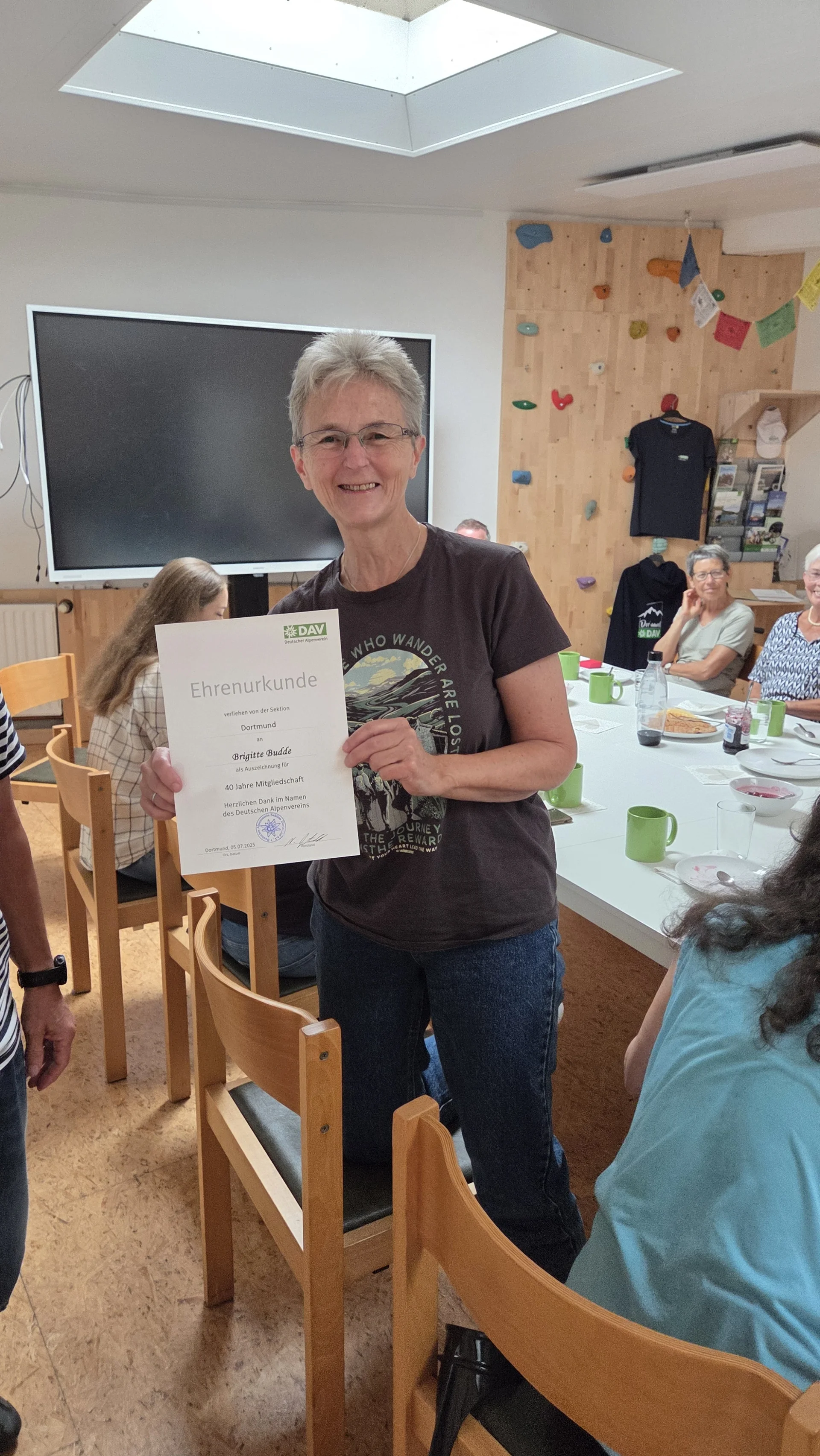 Brigitte hält stolz ihre Ehrenurkunde für 40 Jahre Mitgliedschaft in der DAV Sektion Dortmund in die Kamera. | © DAV Dortmund