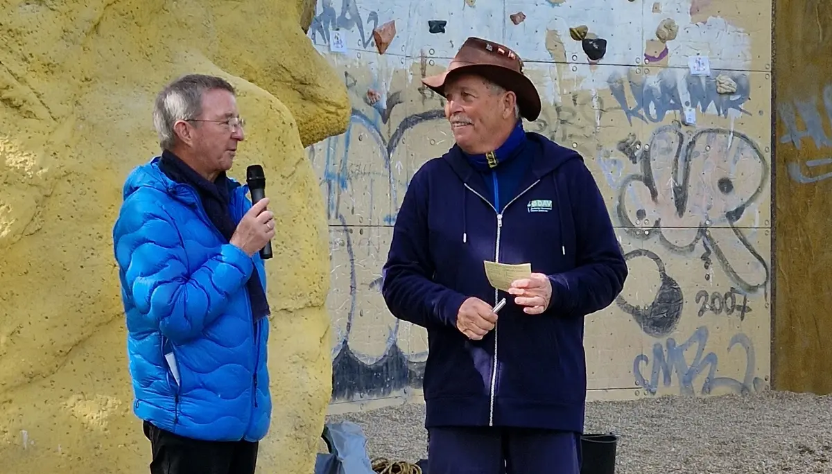 2 Menschen vor einem Kletterturm halten eine Rede | © DAV Dortmund