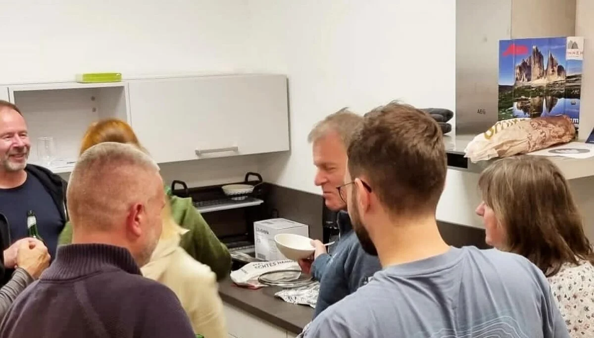 Eine Gruppe steht in einer Küche zusammen, lacht und unterhält sich beim Kochen oder Vorbereiten. | © DAV Dortmund