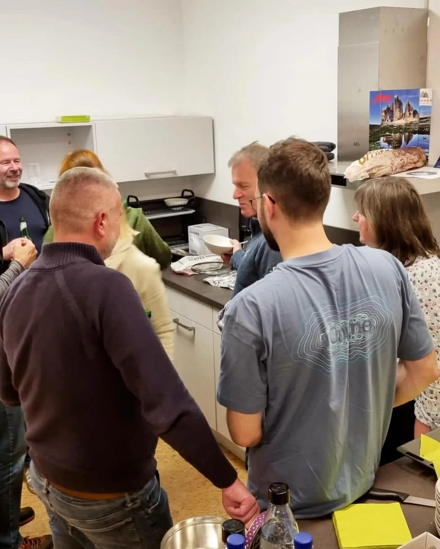 Eine Gruppe steht in einer Küche zusammen, lacht und unterhält sich beim Kochen oder Vorbereiten. | © DAV Dortmund