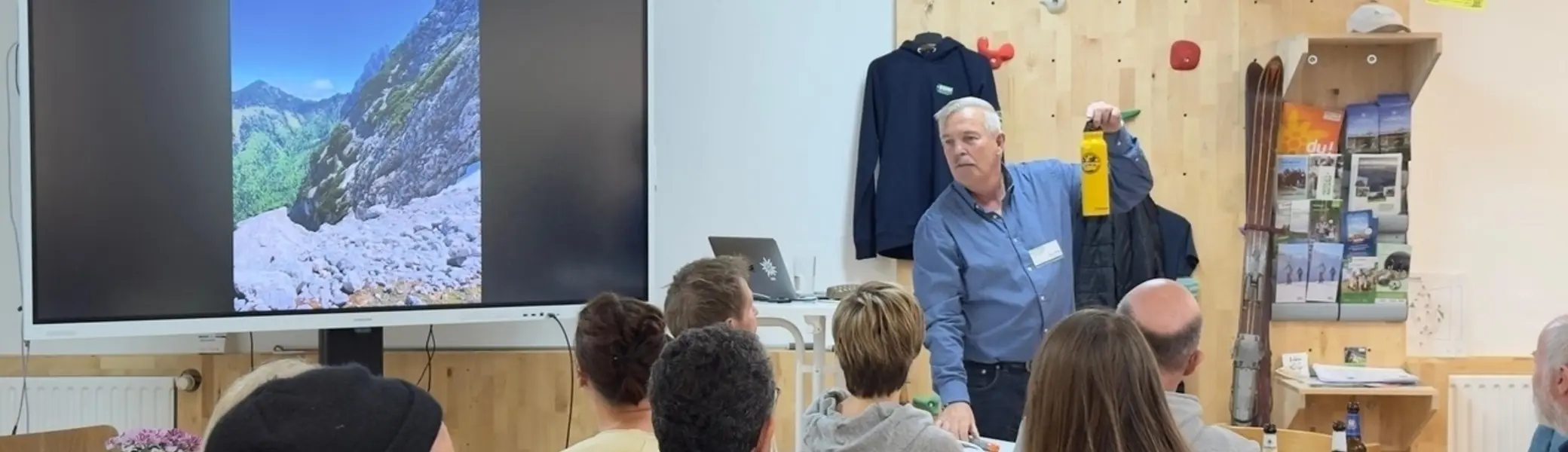 ca 20 Personen sitzen in einem Raum, der Vortragende hält eine Flasche hoch | © DAV Dortmund