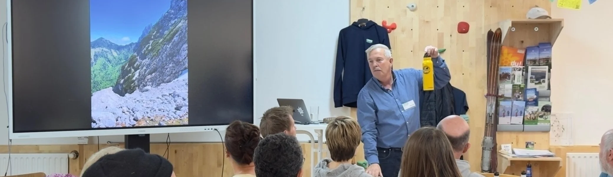 ca 20 Personen sitzen in einem Raum, der Vortragende hält eine Flasche hoch | © DAV Dortmund