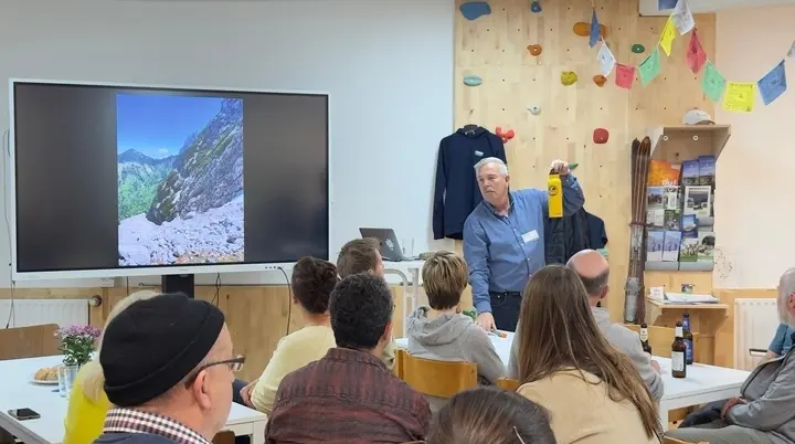 ca 20 Personen sitzen in einem Raum, der Vortragende hält eine Flasche hoch | © DAV Dortmund