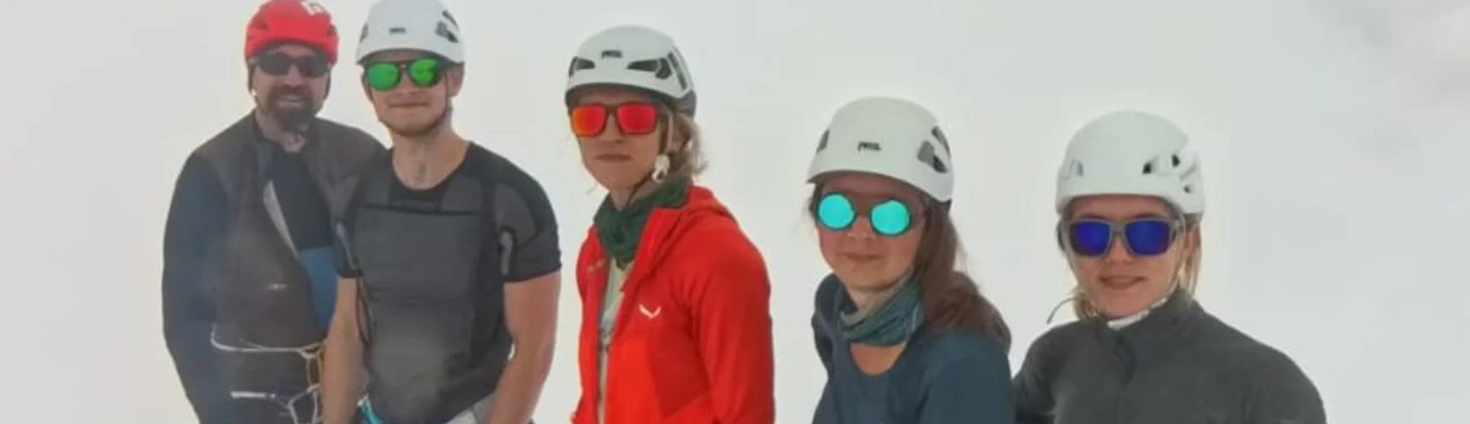  Fünf Bergsteiger*innen mit Helmen und Gurtzeug posieren für ein Gipfelfoto im Schnee. | © DAV Dortmund