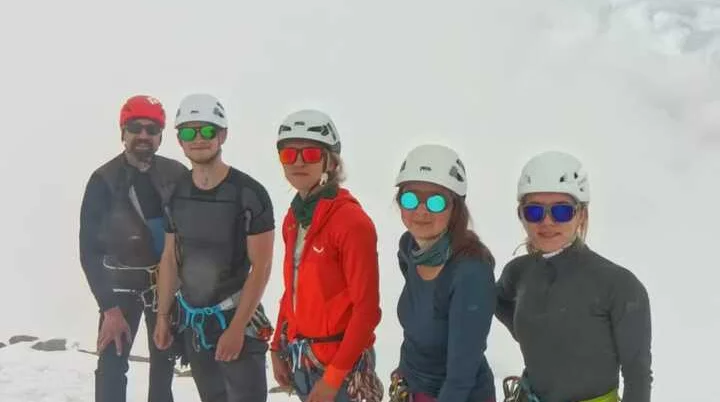  Fünf Bergsteiger*innen mit Helmen und Gurtzeug posieren für ein Gipfelfoto im Schnee. | © DAV Dortmund