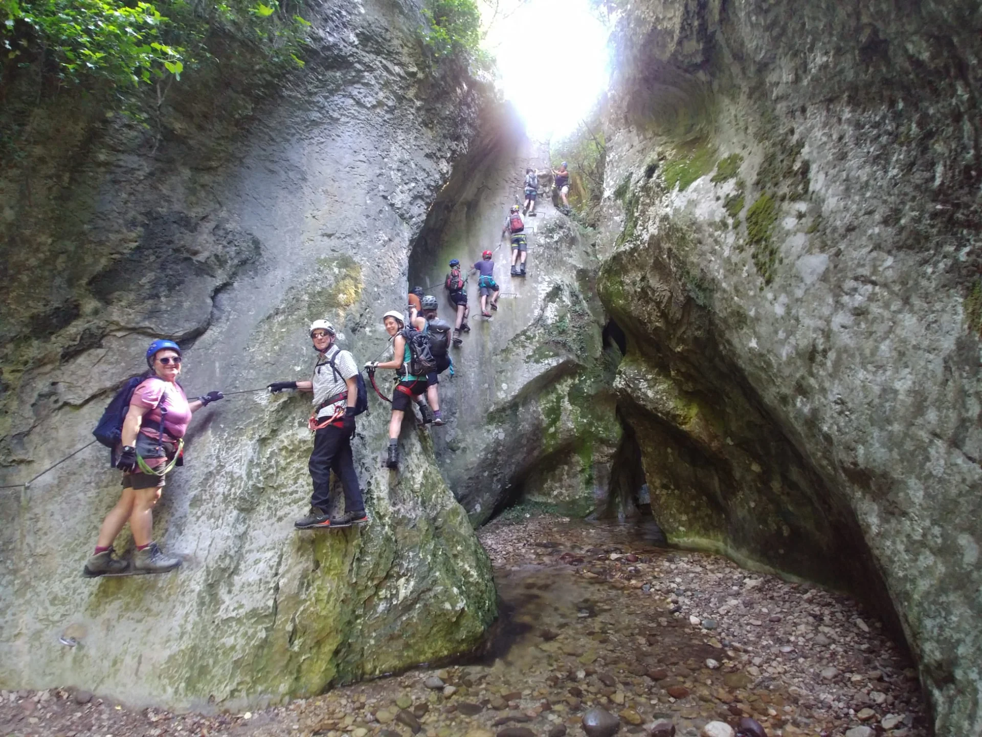 Wandergruppe in Klettersteigausrüstung durchquert eine enge Felsschlucht. | © DAV Dortmund