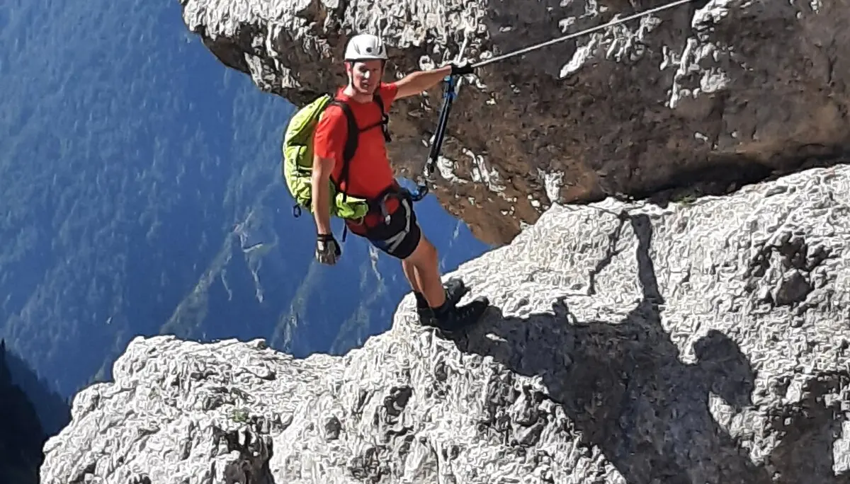 Person mit Kletterausrüstung in einem ausgesetzten Abschnitt eines Klettersteigs. | © DAV Dortmund