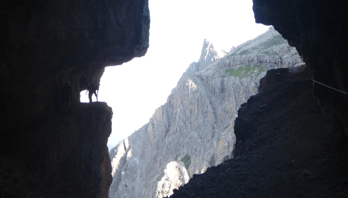 Blick aus einer Felsspalte auf einen spitzen Berggipfel im Hintergrund. | © DAV Dortmund
