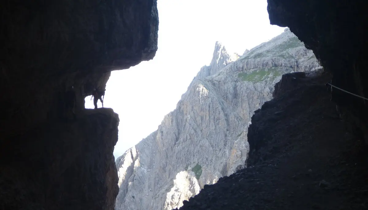 Blick aus einer Felsspalte auf einen spitzen Berggipfel im Hintergrund. | © DAV Dortmund