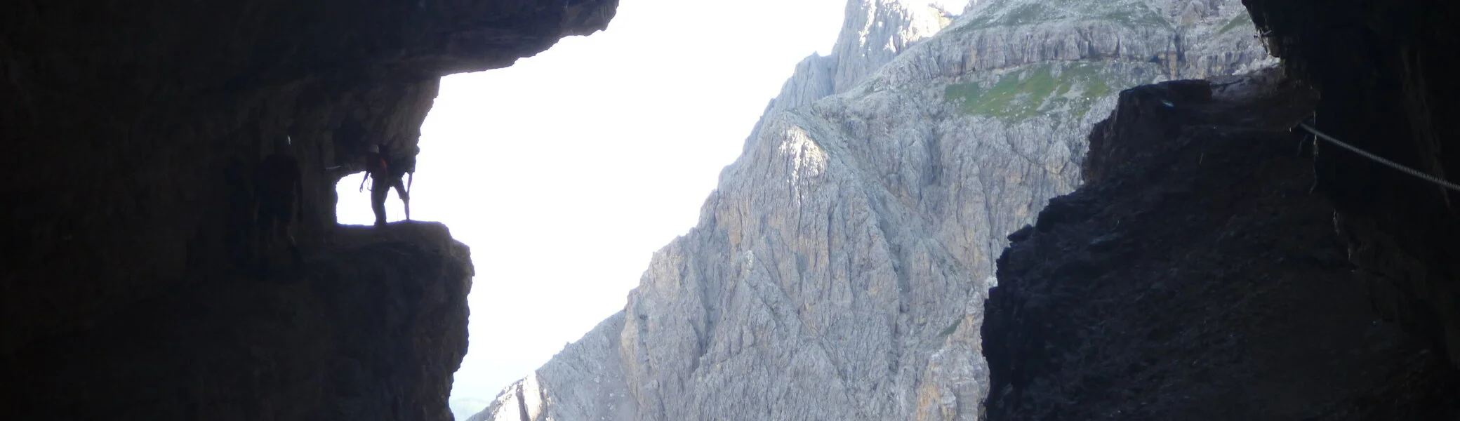 Blick aus einer Felsspalte auf einen spitzen Berggipfel im Hintergrund. | © DAV Dortmund