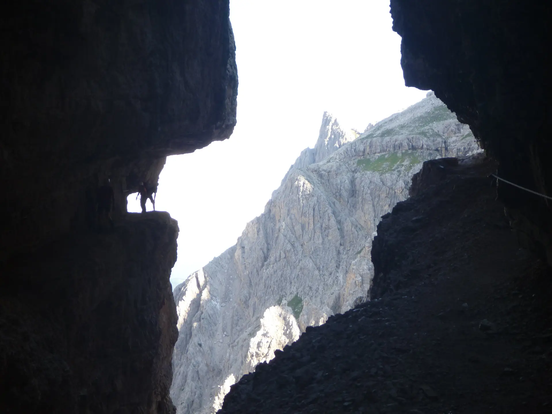Blick aus einer Felsspalte auf einen spitzen Berggipfel im Hintergrund. | © DAV Dortmund