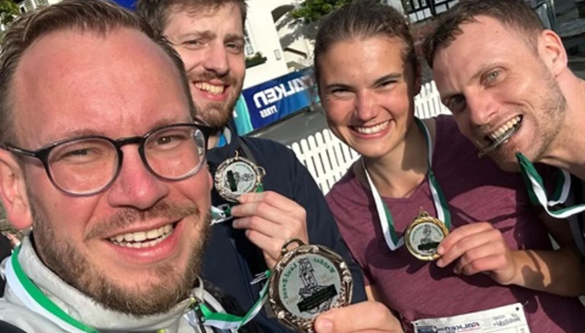 Vier Teilnehmende eines Sportevents zeigen ihre Medaillen und lachen in die Kamera. | © Jens Neuhäuser