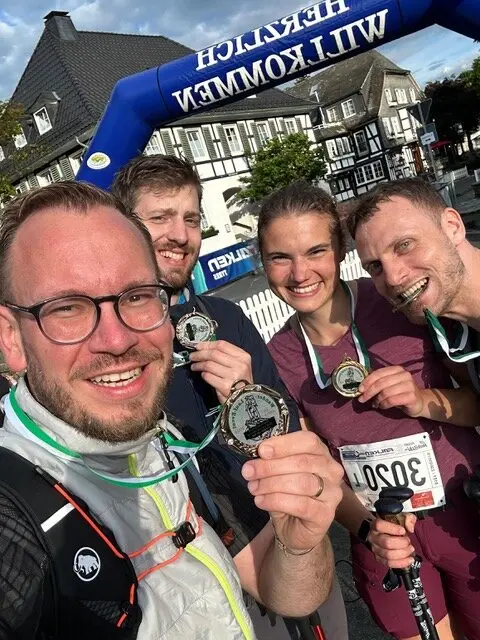 Vier Teilnehmende eines Sportevents zeigen ihre Medaillen und lachen in die Kamera. | © Jens Neuhäuser