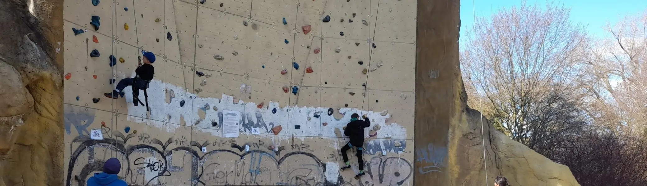 Zwei Kinder Klettern draußen an einem Kletterturm | © DAV Dortmund