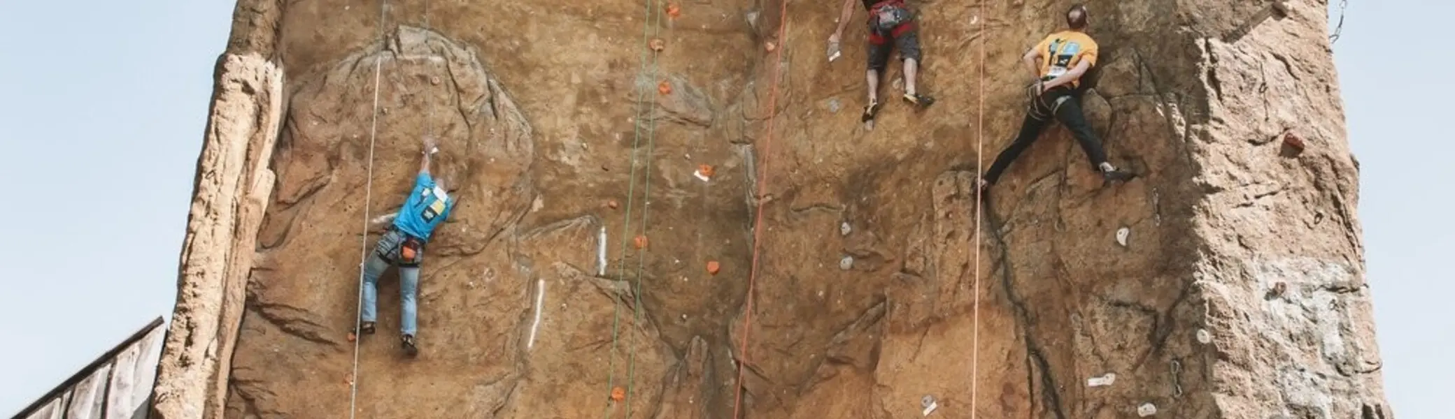 An einem Kletterturm wird geklettert. Zuschauer stehen am Boden | © DAV Dortmund