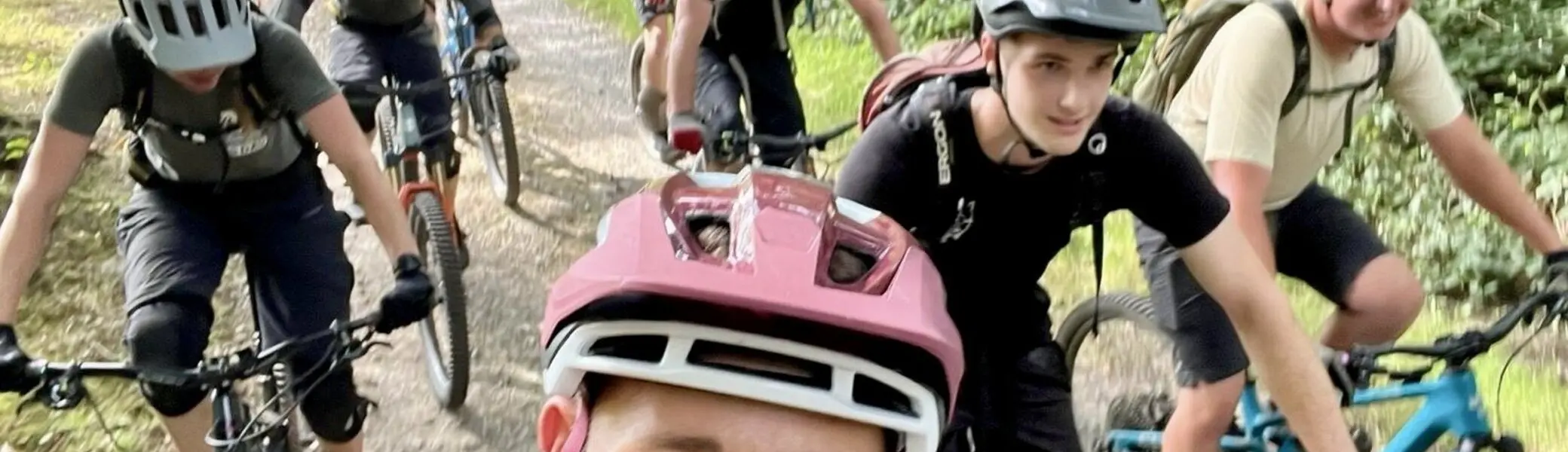 Eine Gruppe von neun Personen auf Mountainbikes, lächelnd bei einer Tour durch den Wald. | © DAV Dortmund