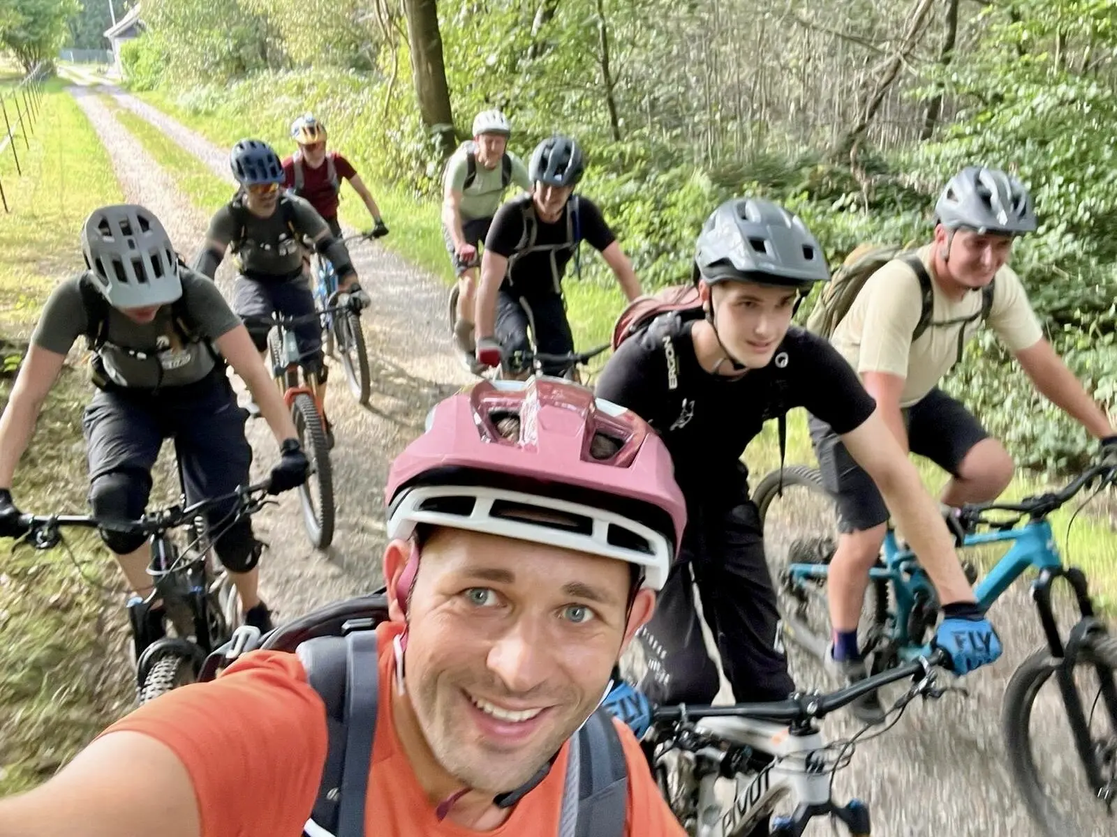 Eine Gruppe von neun Personen auf Mountainbikes, lächelnd bei einer Tour durch den Wald. | © DAV Dortmund