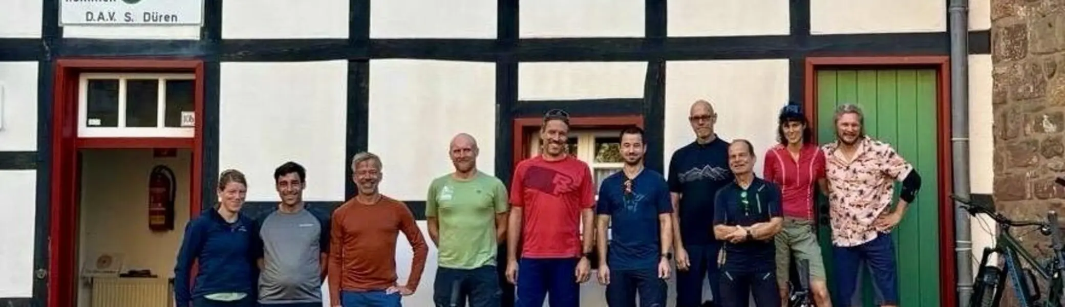 Mountainbikegruppe steht mit Fahrrädern vor einem Fachwerkhaus der DAV Dörnener Hütte. | © DAV Dortmund