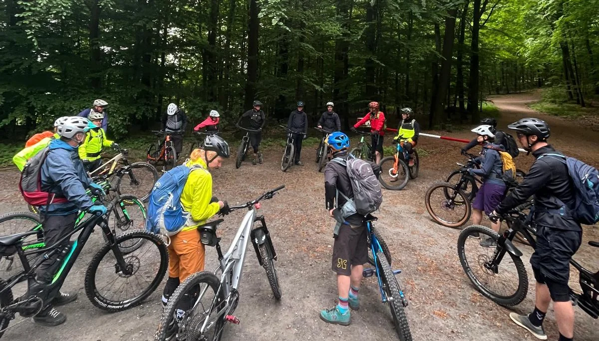 Gruppe von Mountainbiker*innen steht mit ihren Rädern auf einem Waldweg. | © DAV Dortmund