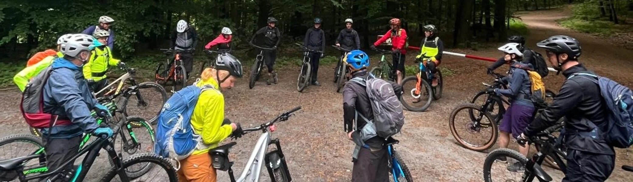 Gruppe von Mountainbiker*innen steht mit ihren Rädern auf einem Waldweg. | © DAV Dortmund